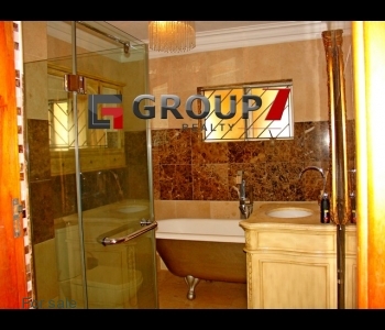 Spacious fully tiled bathroom with shower and bath tub